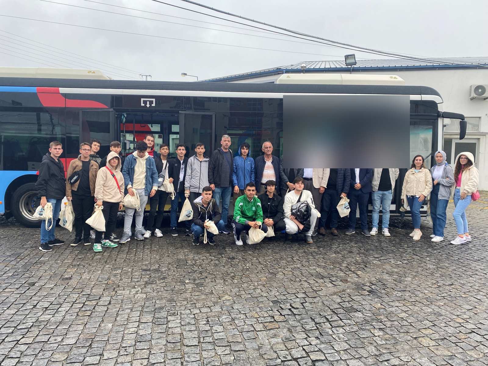 Grupo de participantes com as malas junto ao autocarro, no dia do transfer