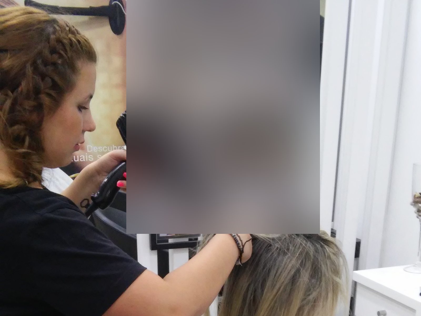 Estagiária de cabeleireiro a fazer um brushing a uma cliente