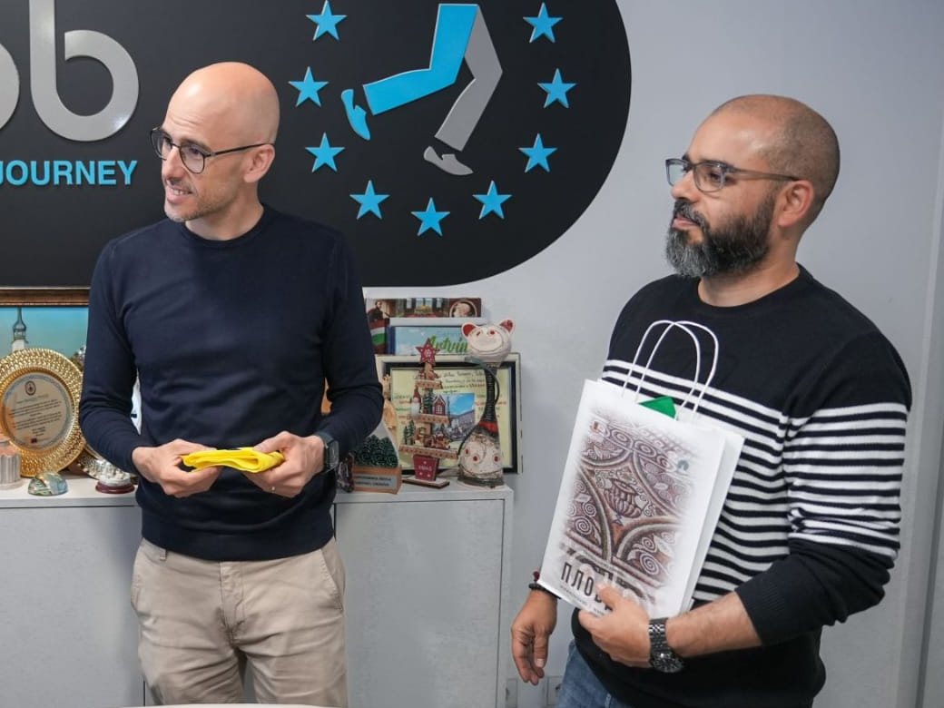 Dois elementos da equipa da BragaMob no escritório, em frente ao logótipo