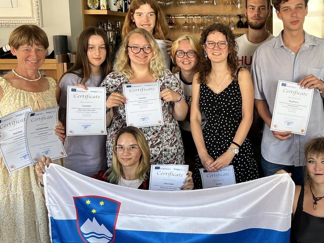 Grupo com a bandeira da Eslovénia e os certificados