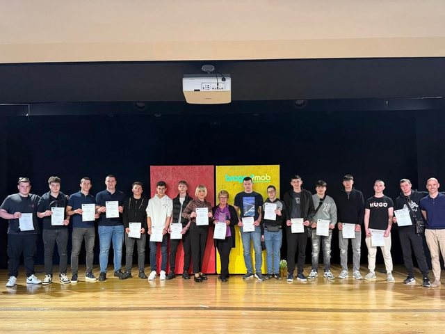 Grupo com os certificados no palco do auditório
