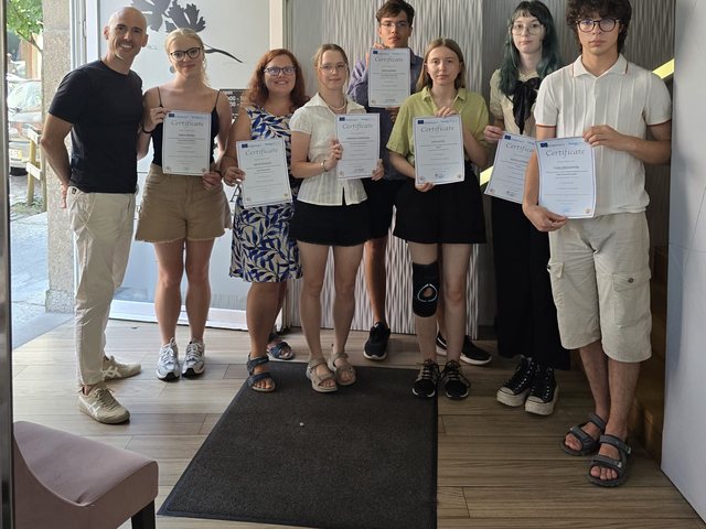 Grupo com os certificados à entrada de um restaurante