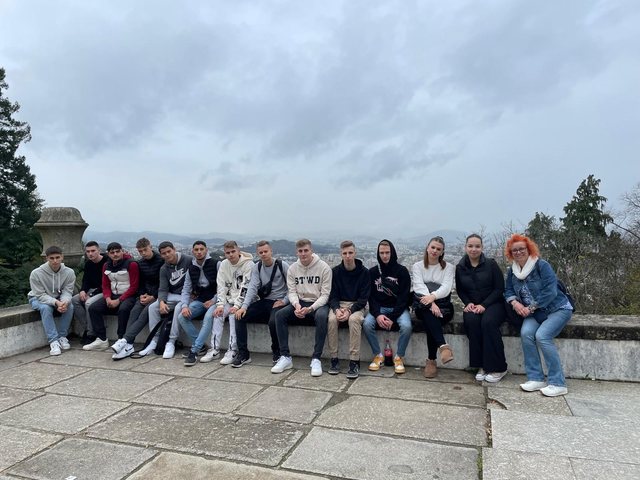 Grupo sentado num muro de um miradouro sobre Braga