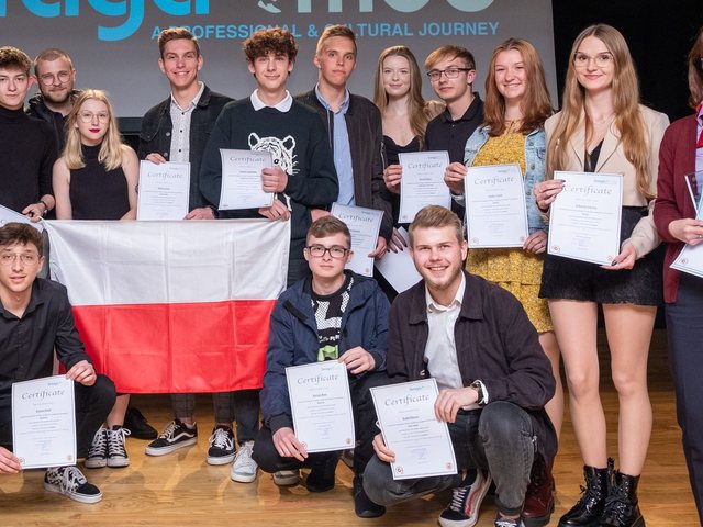 Grupo com a bandeira da Polónia e os certificados no palco