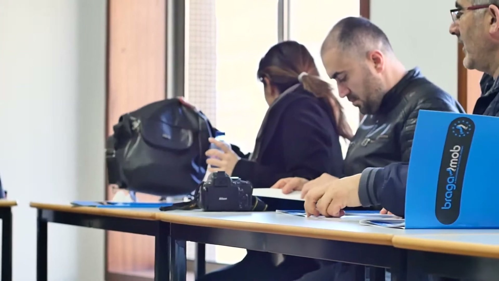 Participantes a ler os documentos da mobilidade nas pastas da BragaMob